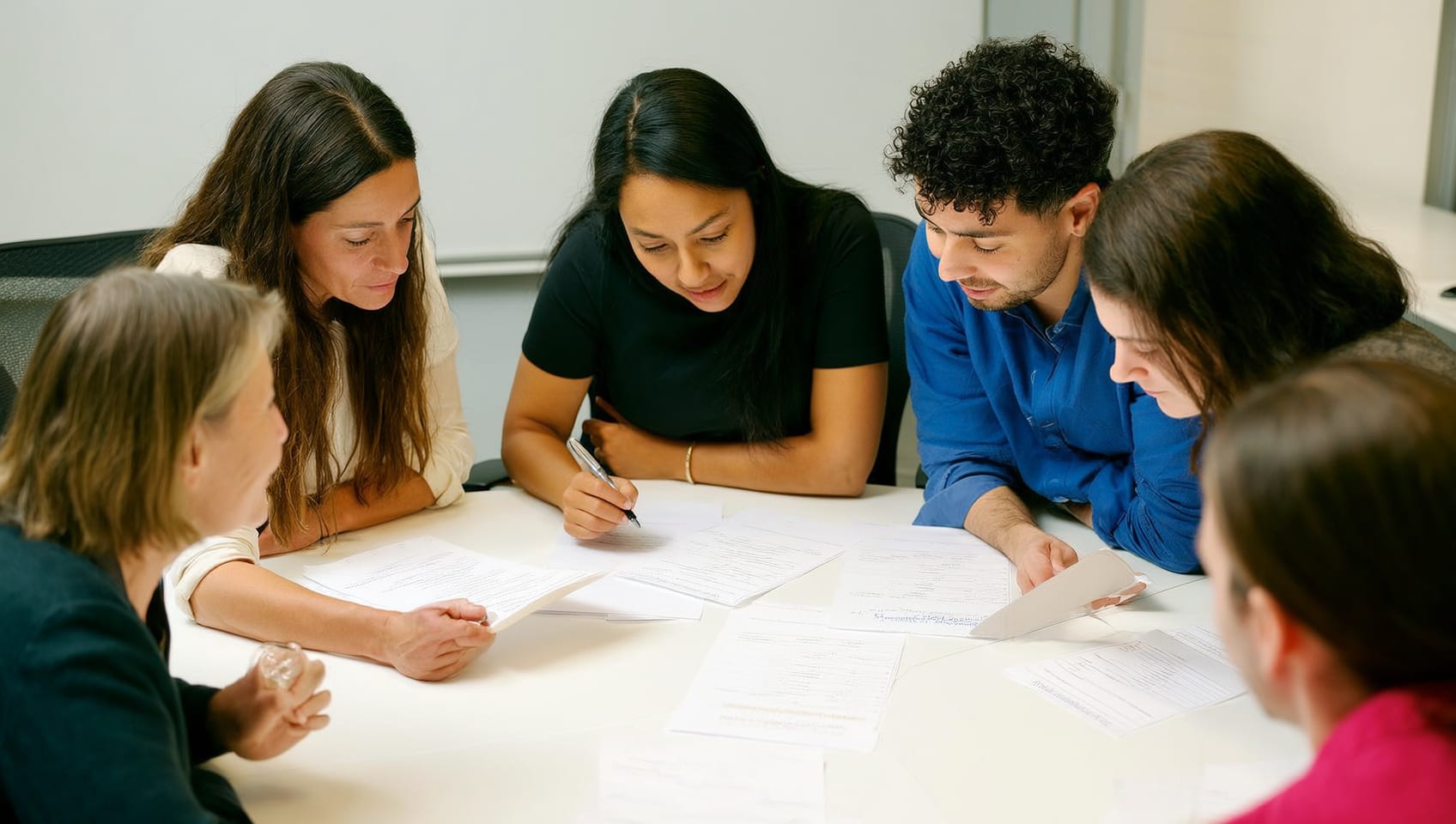 A small team of Foundation staff reviewing a scholarship application together at a bright office table