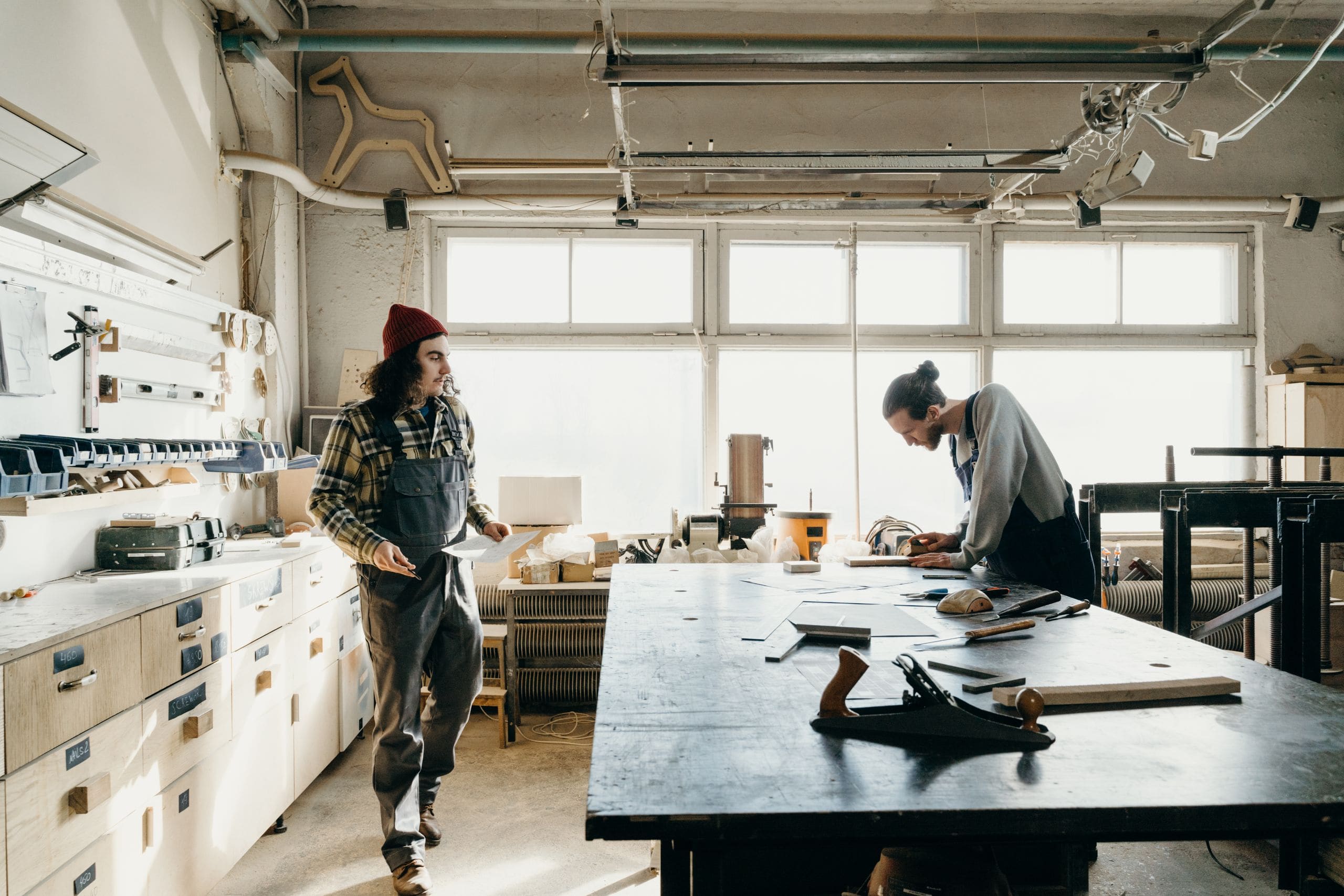 A diverse group of apprentices working together with tools at a hands on trades workshop bench